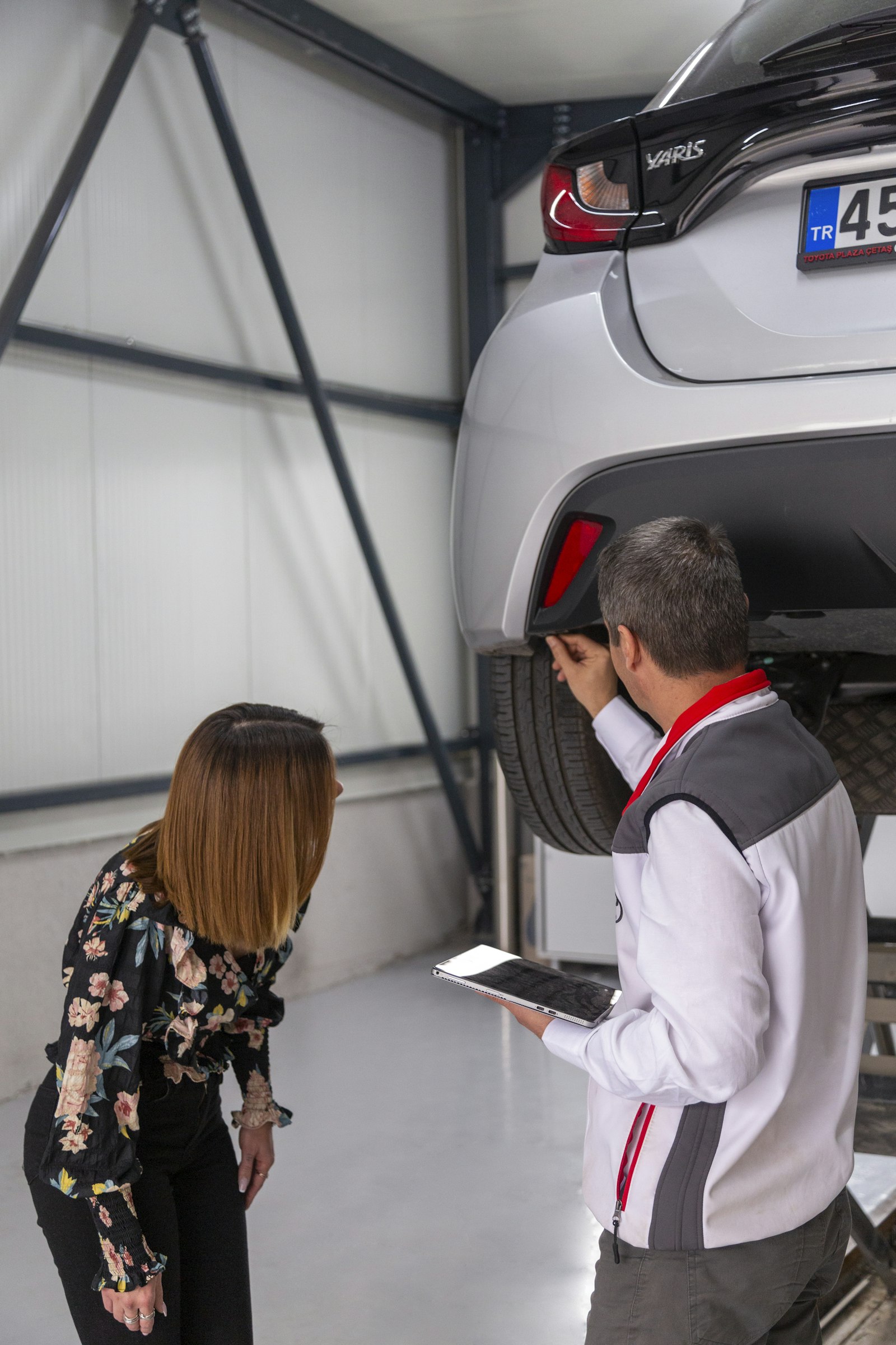 Consultor da autocenter mostra o orçamento no tablet para a cliente