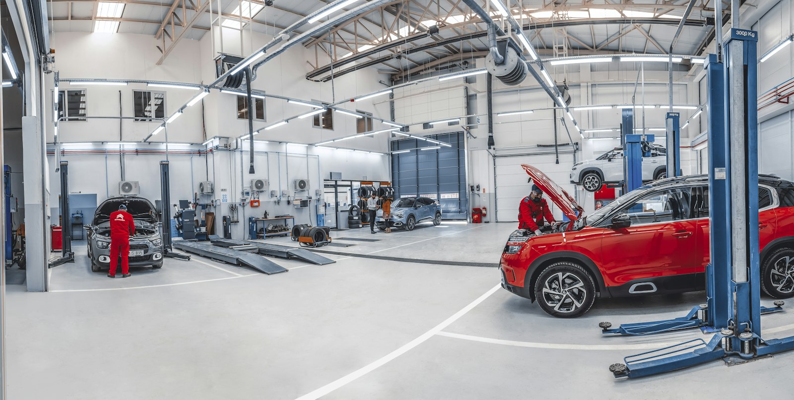 Autocenter moderno, amplo e iluminado, com carros nos elevadores